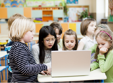 Elementary students around computer during after school program